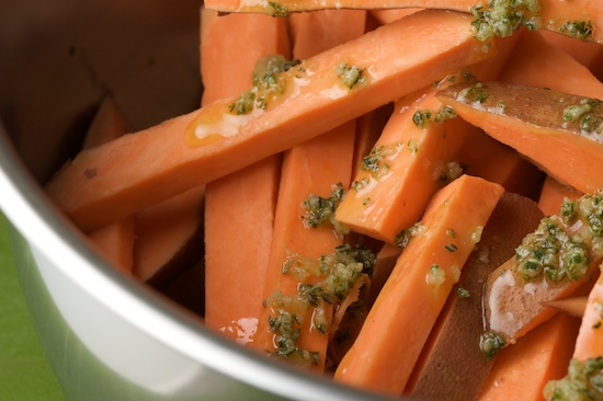 Put the cut sweet potatoes into a large bowl and add the rosemary garlic oil mixture.