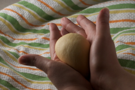 Shape the rolls into balls by rolling against the countertop or between your hands. For smooth rolls, pull the skin taut and pinch together at the bottom.