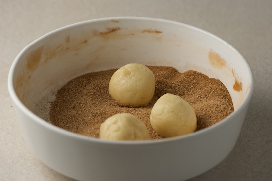 I found that I could put a few balls of dough in the cinnamon/sugar mixture and then shake the whole bowl around to coat them all at once. It was faster and easier!