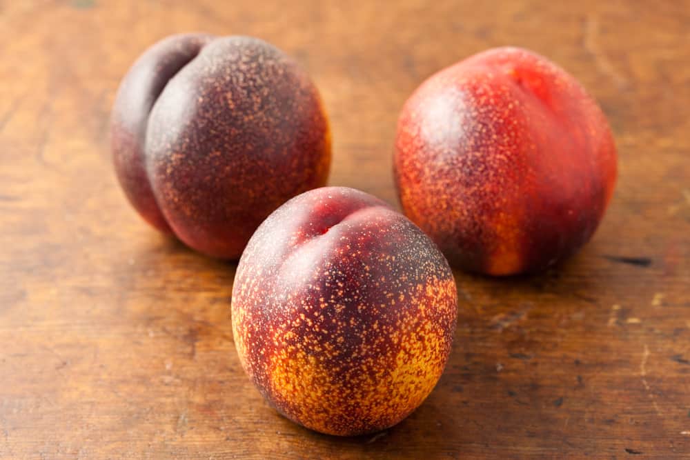 Ripe Nectarines sitting on a board