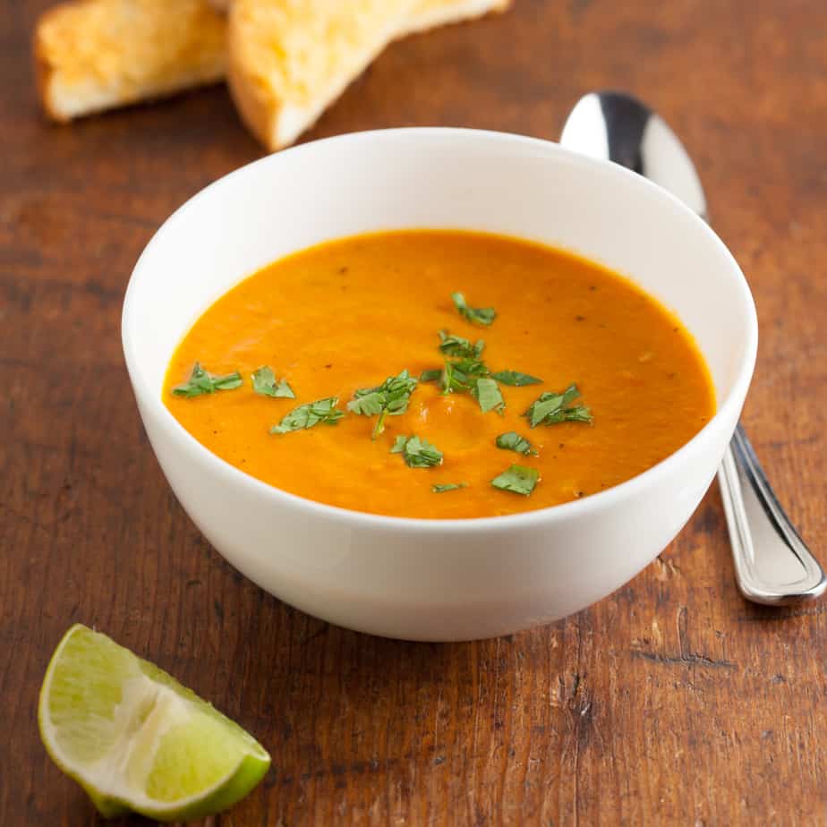 Bowl of Carrot Tomato Chipotle Soup with lime garnish