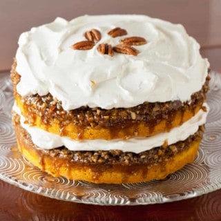 Pumpkin Praline Cake with Whipped Cream Frosting garnished with pecans