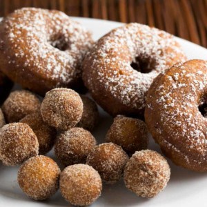 Pumpkin Spice Doughnuts dusted with powdered sugar on a plate