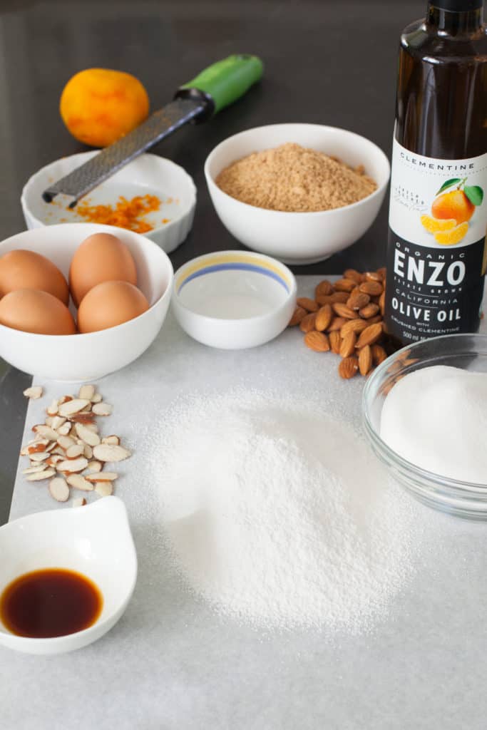 Ingredients for citrus almond olive oil cake, including: eggs, roasted almond meal, orange zest, citrus flavored olive oil, cake flour, sugar, and vanilla