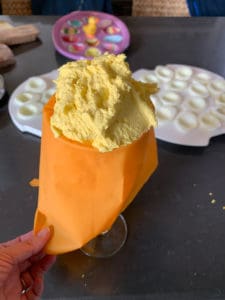 Filling a piping bag with deviled egg filling