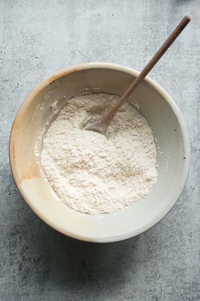Stir grated butter into the flour mixture with a wooden spoon.